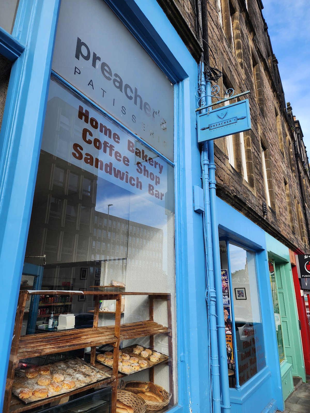 The blue shopfront of Preacher's Patisserie on Lady Lawson Street, Edinburgh, with trays of fresh scones in the window